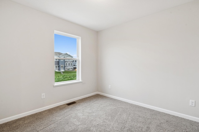 carpeted empty room featuring visible vents and baseboards