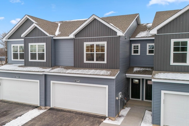 townhome / multi-family property featuring board and batten siding, a shingled roof, and a garage