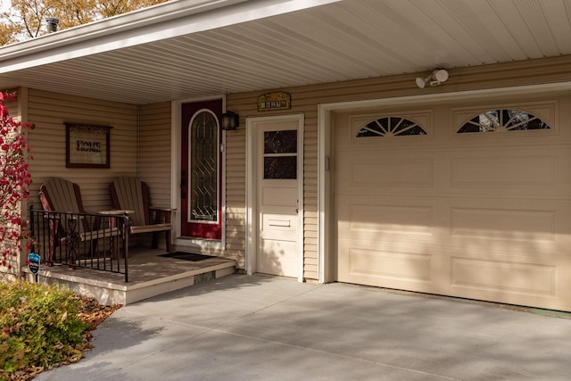 entrance to property featuring a porch and a garage