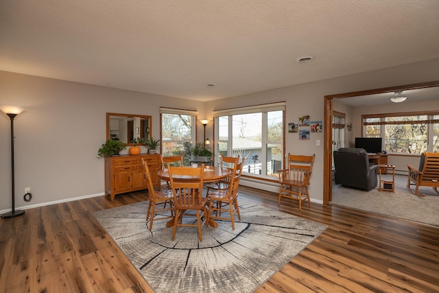 dining room featuring dark hardwood / wood-style floors and a textured ceiling