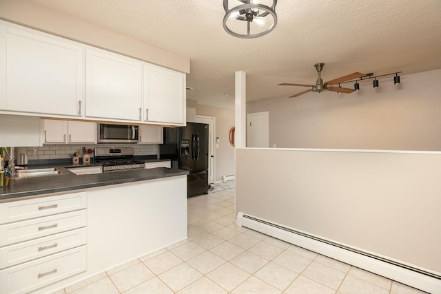 kitchen with white cabinets, a baseboard heating unit, stainless steel appliances, decorative backsplash, and sink