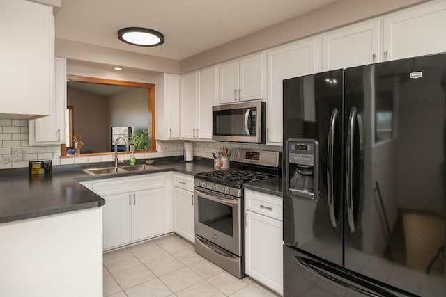 kitchen with sink, white cabinetry, light tile patterned floors, and appliances with stainless steel finishes