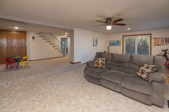 living room featuring ceiling fan, a textured ceiling, and carpet flooring