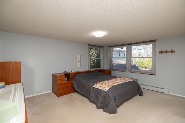 carpeted bedroom with a textured ceiling and a baseboard heating unit