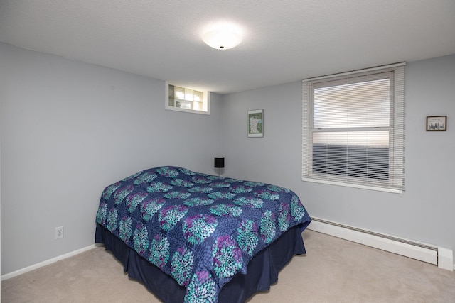 carpeted bedroom with a baseboard heating unit and a textured ceiling