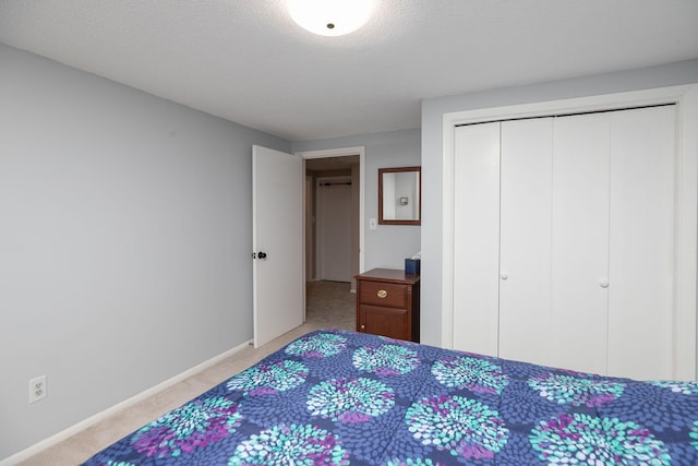 carpeted bedroom with a closet and a textured ceiling