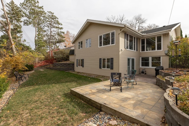 back of property featuring a patio and a yard