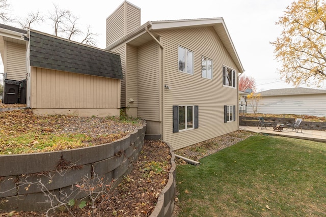 view of side of home featuring a lawn and a patio