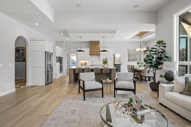 living room featuring light wood-type flooring and a notable chandelier