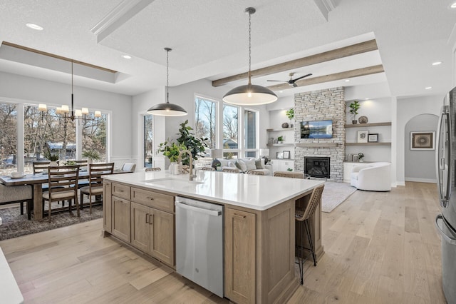 kitchen featuring appliances with stainless steel finishes, sink, decorative light fixtures, and a kitchen island with sink