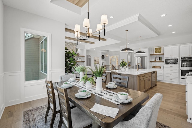 dining room with light wood-type flooring and an inviting chandelier