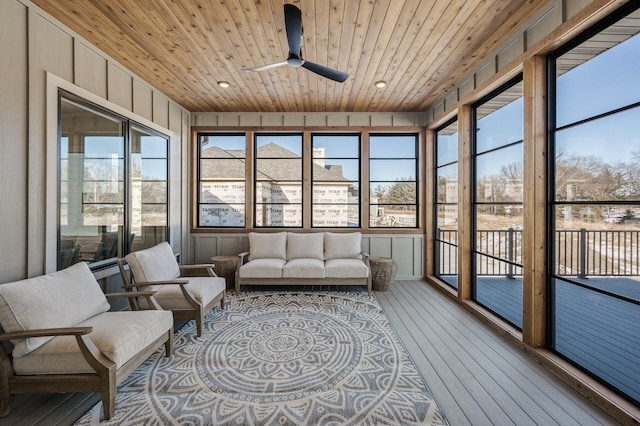 sunroom with ceiling fan, wooden ceiling, and plenty of natural light