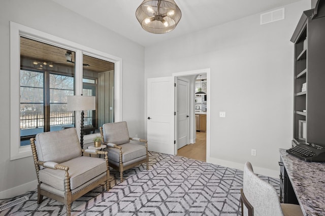 sitting room with a chandelier and light hardwood / wood-style floors