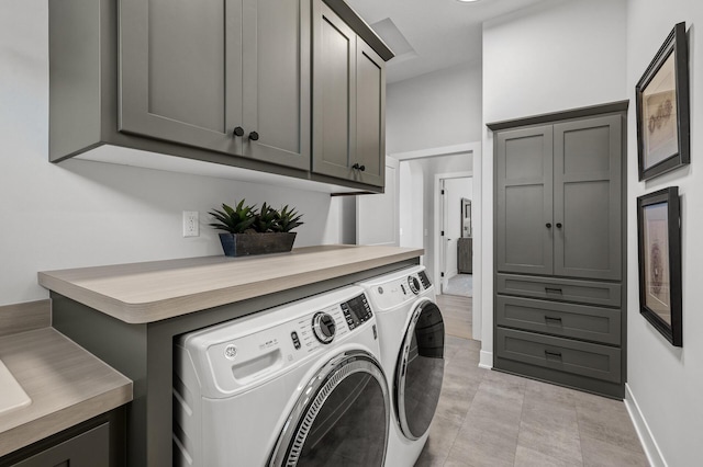 laundry area with washing machine and dryer and cabinets