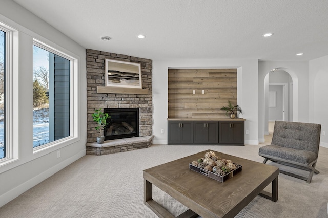 carpeted living room with a textured ceiling and a fireplace