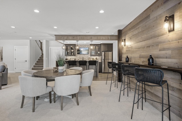 dining area with wooden walls and bar area