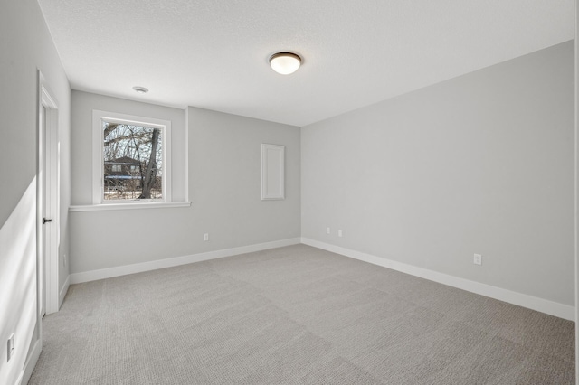 carpeted spare room featuring a textured ceiling