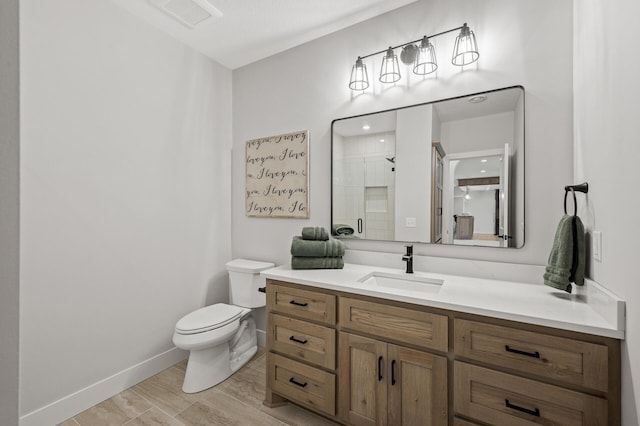 bathroom featuring toilet, vanity, a shower with shower door, and hardwood / wood-style floors