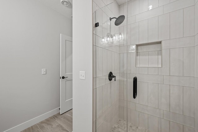 bathroom with a textured ceiling and a shower with door