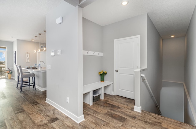 mudroom featuring dark wood-type flooring and a textured ceiling