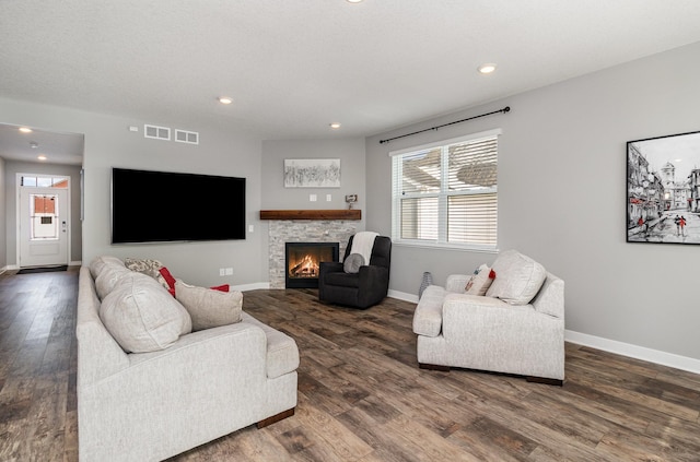 living room featuring dark wood-type flooring and a fireplace