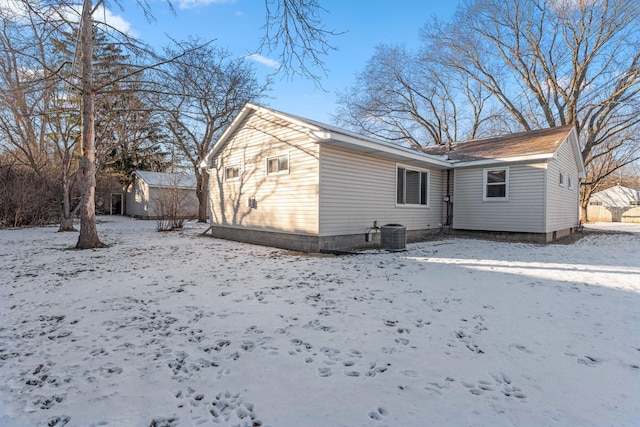 snow covered house featuring cooling unit