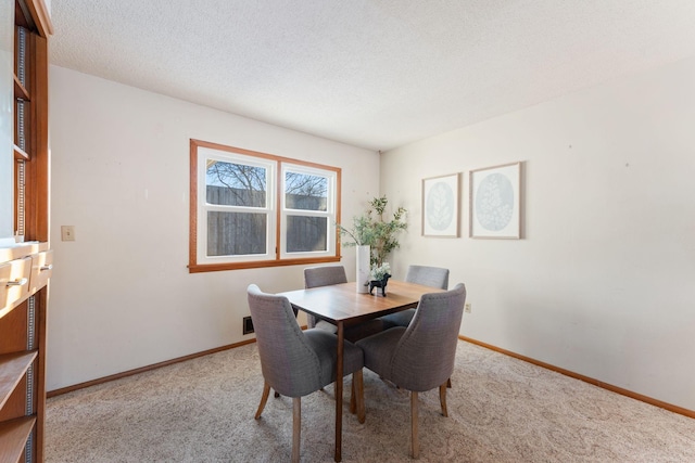 dining room with light carpet and a textured ceiling