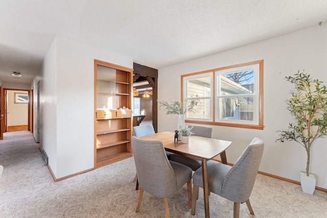 dining room with light carpet and a textured ceiling