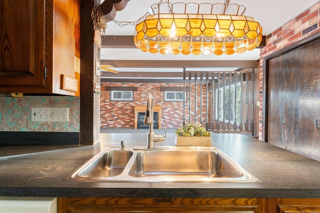 kitchen with dishwashing machine, brick wall, sink, and backsplash