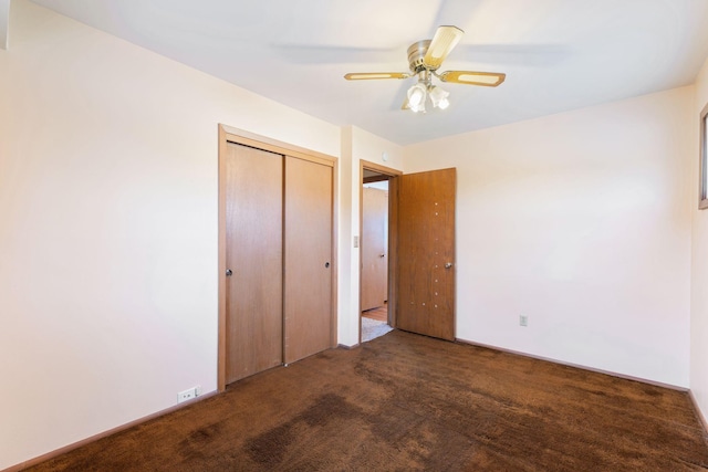 unfurnished bedroom featuring dark colored carpet, ceiling fan, and a closet