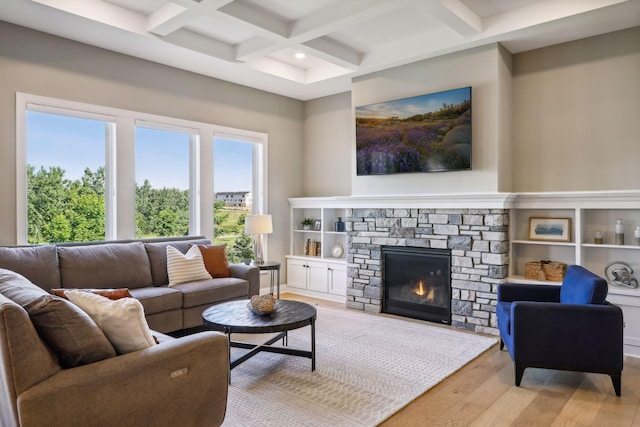 living room featuring light wood-type flooring, coffered ceiling, beam ceiling, and a fireplace