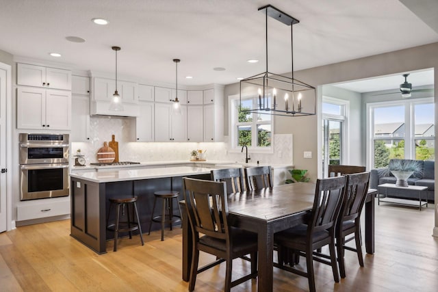 dining area with light hardwood / wood-style floors and ceiling fan