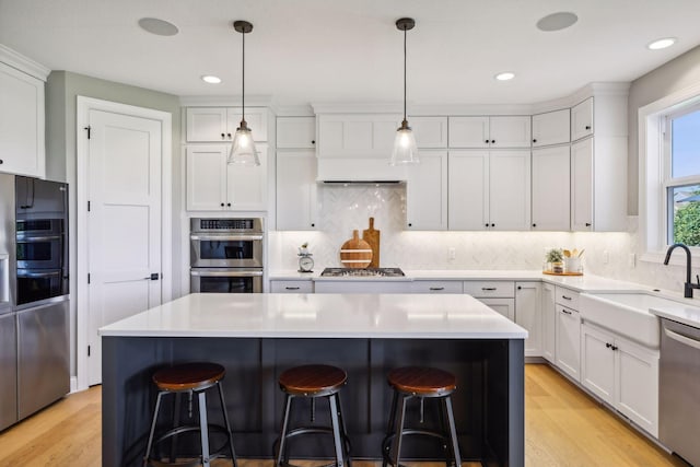 kitchen with white cabinets, a center island, and stainless steel appliances