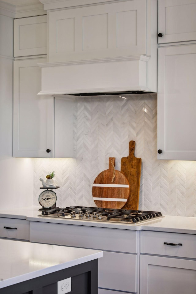 details featuring white cabinetry, stainless steel gas cooktop, and tasteful backsplash