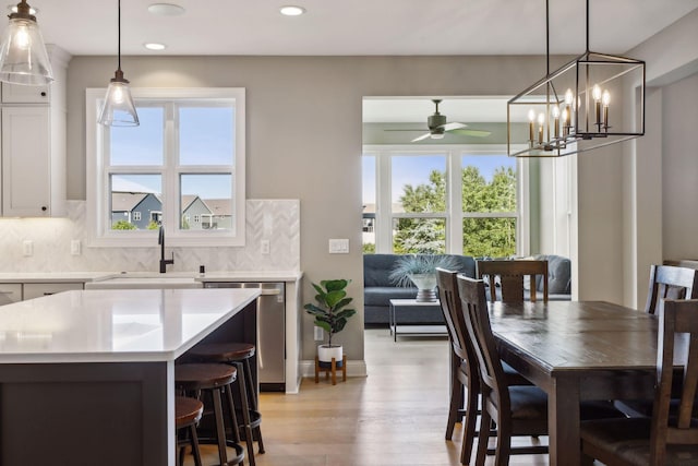 interior space featuring pendant lighting, white cabinets, dishwasher, and tasteful backsplash