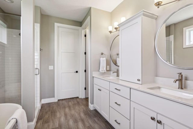 bathroom with hardwood / wood-style flooring, separate shower and tub, and vanity