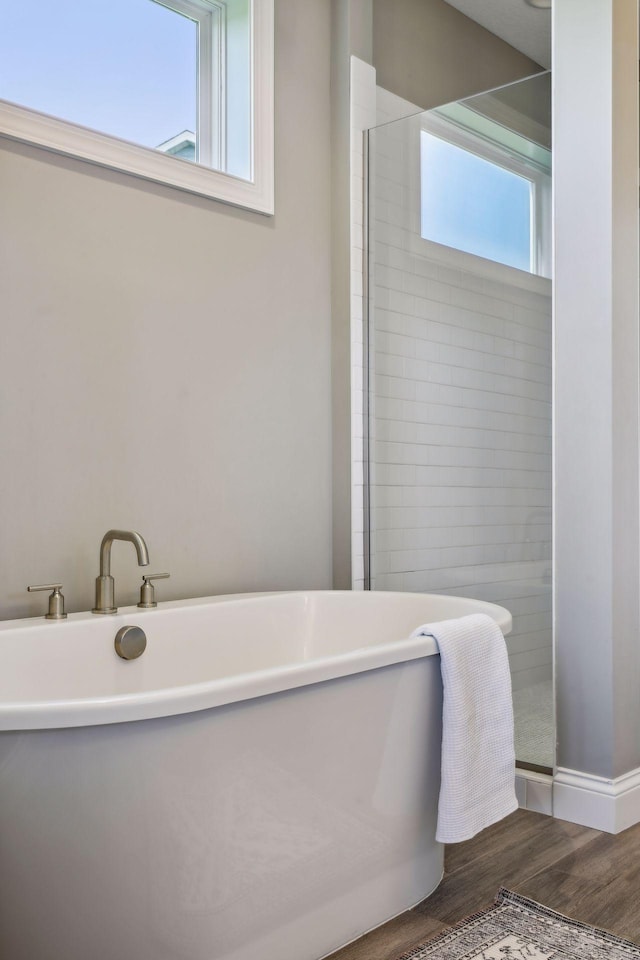 bathroom featuring wood-type flooring and separate shower and tub