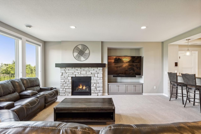 carpeted living room featuring a stone fireplace