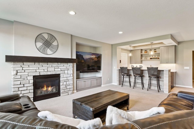 carpeted living room featuring a textured ceiling and a fireplace