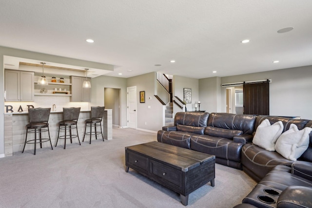 carpeted living room featuring sink and a barn door