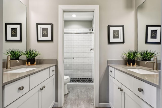 bathroom with tile patterned flooring, toilet, a shower with door, and vanity