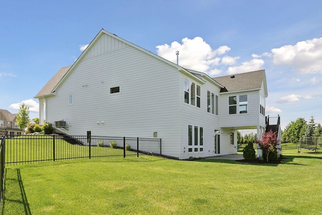 rear view of property featuring a yard and central air condition unit