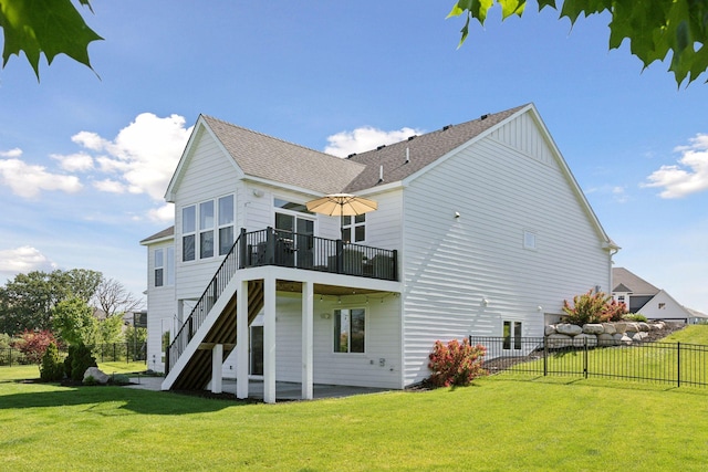 rear view of house featuring a wooden deck and a yard