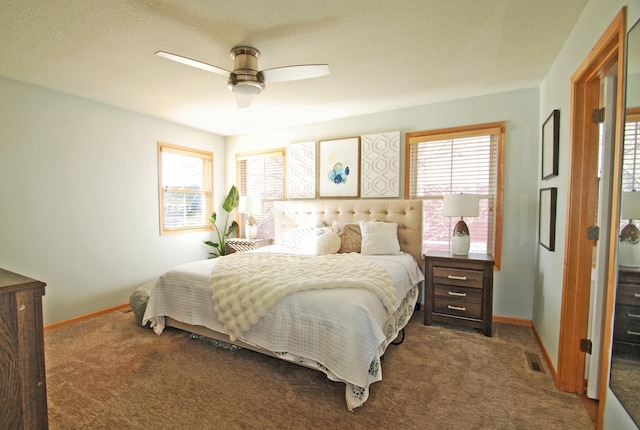 carpeted bedroom featuring multiple windows, a textured ceiling, and ceiling fan