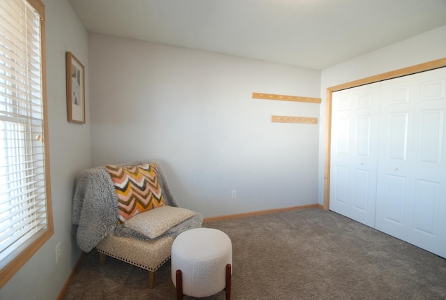 sitting room featuring dark colored carpet