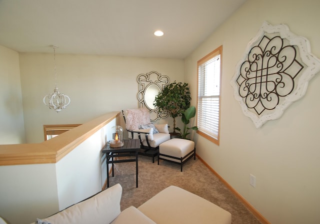 sitting room with a chandelier and carpet flooring