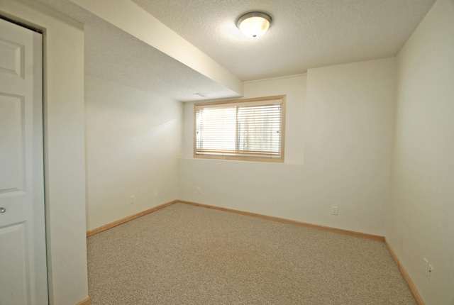 carpeted empty room with a textured ceiling