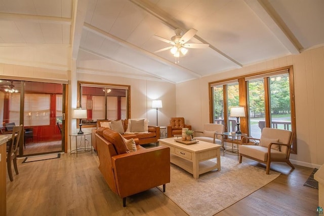 living room with light hardwood / wood-style floors, ceiling fan, and vaulted ceiling with beams