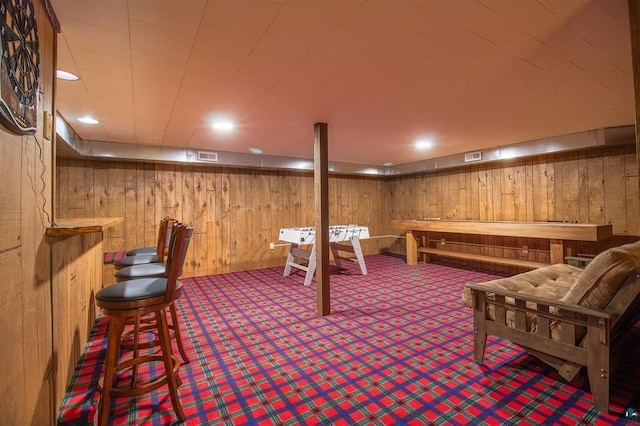 recreation room featuring wood walls and carpet flooring