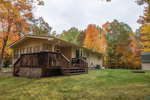 rear view of house featuring a deck, a yard, and central AC unit